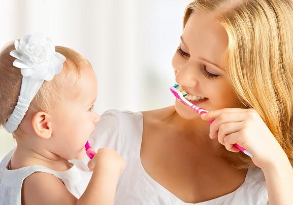 happy family and health. mother and daughter baby girl brushing their teeth together