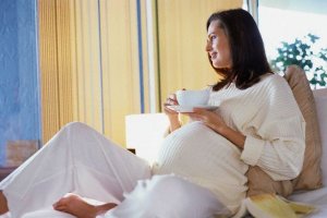 Pregnant Woman Drinking in Bed